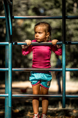 beautiful little girl playing on children's sports trainers climbs the stairs