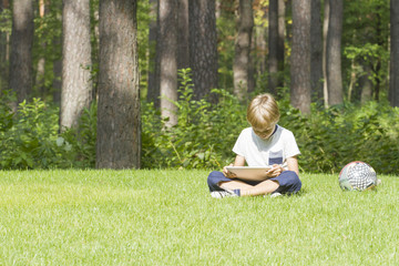 Smart boy using a tablet outdoors. Technology, lifestyle, education, people concept