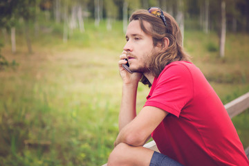 Young man holding mobile phone, making a call and speaking on the phone.