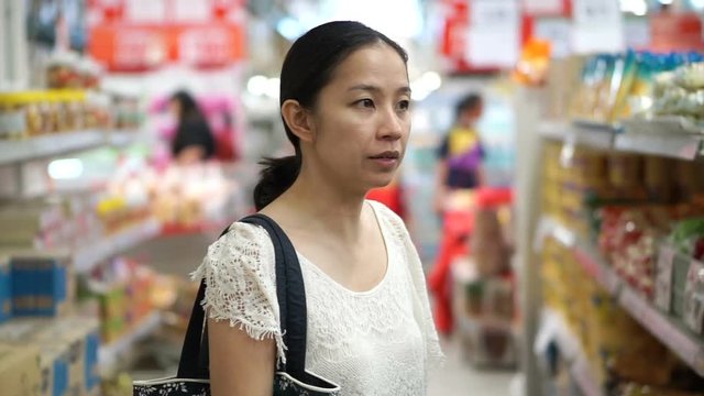 Asian girl, woman shopping for food in wholesale supermarket