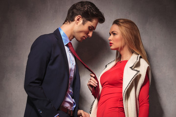  blonde woman in red dress pulling her lover by tie