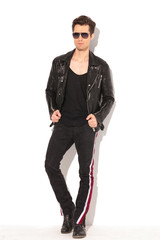 Fototapeta premium full body picture of a man in leather jacket and sunglasses