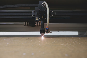 Laser cutting machine carving patterns on the plastic plate.