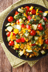 Vegetable salad of corn, greens, tomatoes, cucumbers and pepper. vertical top view
