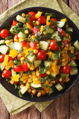 Low calorie salad of corn, tomatoes, cucumbers and pepper closeup. vertical top view
