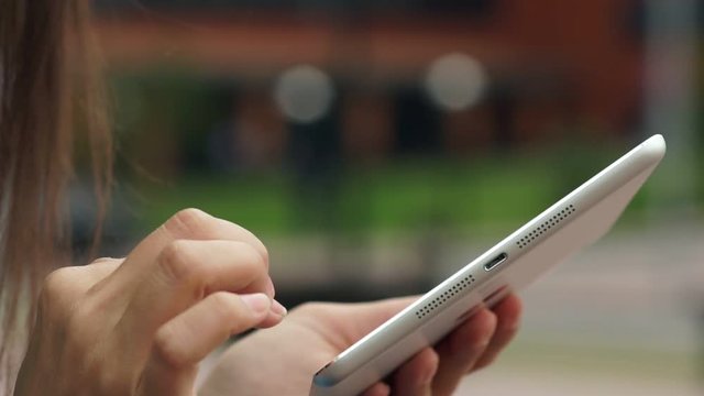 Women's hands with the white tablet. Using a touchscreen tablet, slow