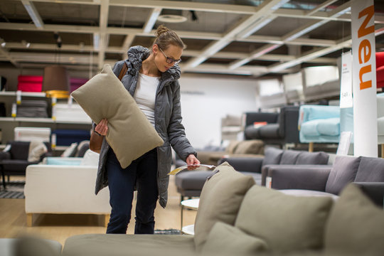 Pretty, young woman choosing the right furniture 