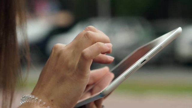 Women's hands with the white tablet. Using a touchscreen tablet, slow
