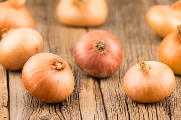 Onions on old wooden table.