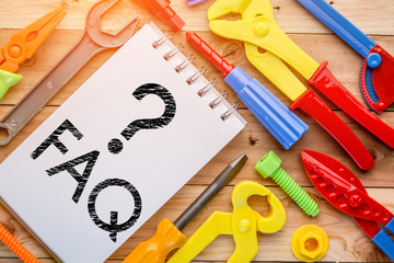 Working tools toys and notebook with faq word