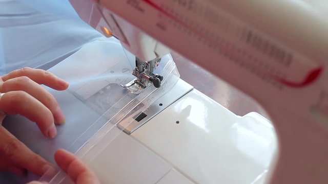 Woman sews on the sewing machine. Women's hands. professional work. Close-up.