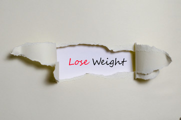 The word lose weight appearing behind torn paper
