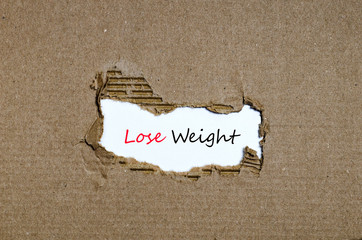 The word lose weight appearing behind torn paper
