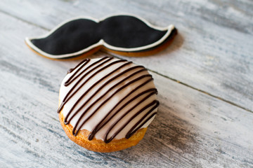Biscuits with icing. Sweets on gray wooden background. Bush cake and moustache cookie. Snack for a true gentleman.