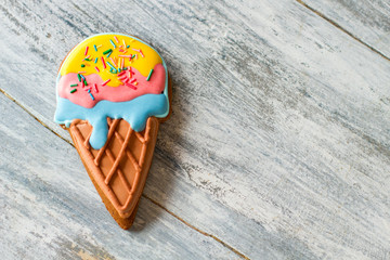Cookie shaped as ice cream. Colorful biscuit on gray background. Good taste and bright colors. Glaze made of sugar.