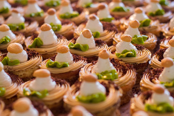 Rows of small decorated cakes. Chocolate crumbs and cream. Appetizing fresh desserts. Sweet treats in cafe.