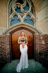 Attractive bride in amazing white dress near old door
