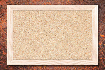 Fototapeta premium Cork board or Empty bulletin board with a wooden frame on rusty metal background with copy space for text or image.