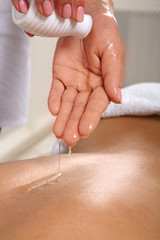 Massagist make oil body massage in spa wellness center