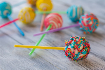 Colorful candy on stick. Glazed cake pop. Children will be in mood. Small dessert with cream filling.