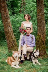 Amazing wedding couple with huskies in forest