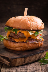 Tasty grilled burger with lettuce and mayonnaise ,on a rustic wooden table