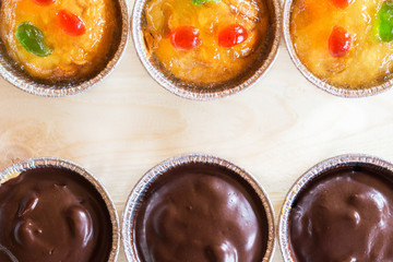 Homemade juicy fruit and chocolate cupcake on wooden background