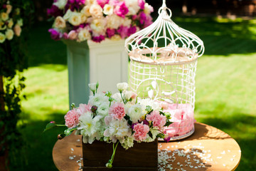 Wedding decoration with flowers and cage for ceremony outside