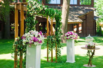 Fototapeta na wymiar Amazing wedding decoration with flowers and arch for ceremony ou