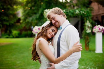 Fototapeta premium Lovely wedding couple is hugging near decorated arch