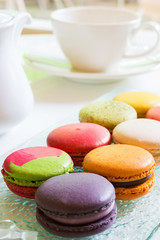 The delicacy of a french sweet, the colorful macaroons on plate with afternoon tea