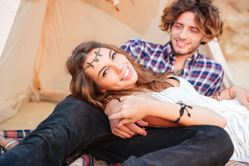 Couple lying together in wigwam on the beach © Drobot Dean