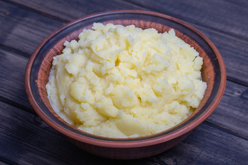 Mashed potatoes in a plate on the wooden table