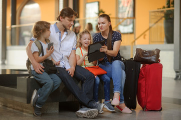 Parents with two children at the railway station.