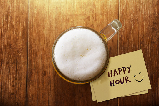 Glass of Beer on the Wooden Table at Bar with Paper Note and Word : Happy Hour, Promotional Concept