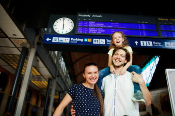 Young couple with his little daughter at the train station.