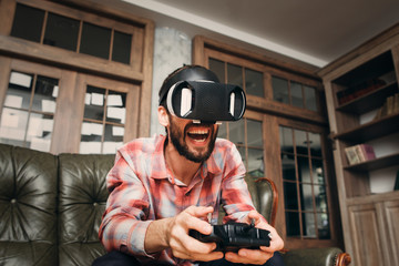 Excited man playing video game in vr glasses with joystick. 3d virtual headset impressed male adult. Modern technology, innovation, cyberspace, entertainment, gaming concept