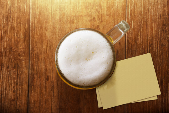 Glass of Beer on the Wooden Table at Bar with Blank Paper Note