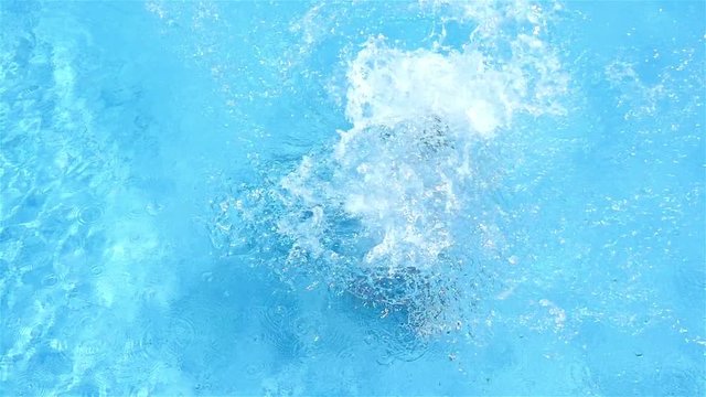 Slow motion of a little girl jumping in a pool