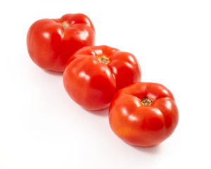 A tomato. Red tomato on a white background. Harvest vegetables. Autumn harvest. Red, juicy, ripe tomato.
