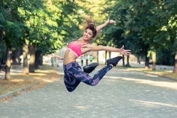 pretty young woman jumping in the park, happy, training