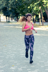 Running woman in a Park. Beautiful fit Girl. Fitness model