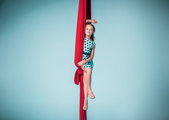 Graceful gymnast sitting with red fabrics
