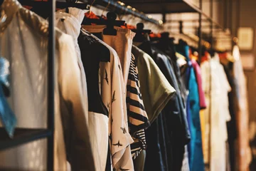 Fotobehang Clothes on racks in a fashion boutique © agcreativelab