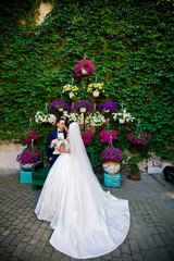 Lovely wedding couple among colorful city flowers