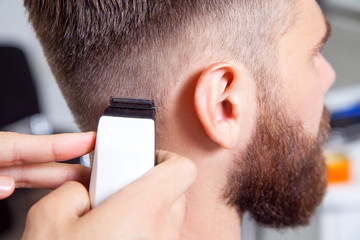 Barber cutting and modeling hair by electric trimmer