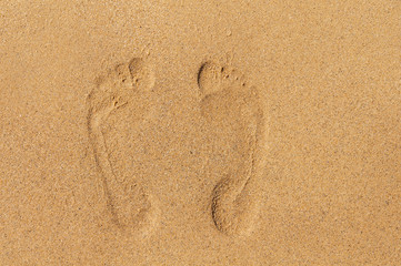 Fototapeta na wymiar Two footprints in sand on beach
