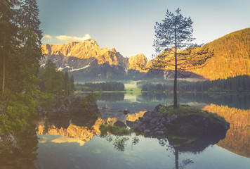 Jezioro alpejskie  o świcie,pięknie oświetlone szczyty gór,kolorystyka retro,vintage



