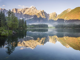 Jezioro alpejskie  o świcie,pięknie oświetlone szczyty gór

 - obrazy, fototapety, plakaty