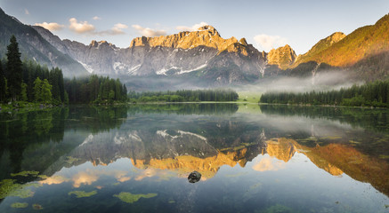 Jezioro alpejskie  o świcie,pięknie oświetlone szczyty gór

 © Mike Mareen